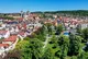 Aufnahme einer Kleinstadt von schräg oben, in der rechten unteren Bildecke ein Park mit Bäumen, sonst Häuser und im Hintergrund eine große Kirche.
