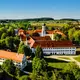 Klosteranlage Bad Schussenried aus der Vogelperspektive mit Bäumen und blauem Himmel