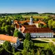 Klosteranlage Bad Schussenried aus der Vogelperspektive mit Bäumen und blauem Himmel