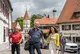 Vier Menschen schlendern durch ein idyllisches Städtchen.