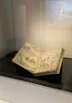 Ein großes Buch mit Zeichnungen liegt aufgeschlagen in einer Vitrine. 